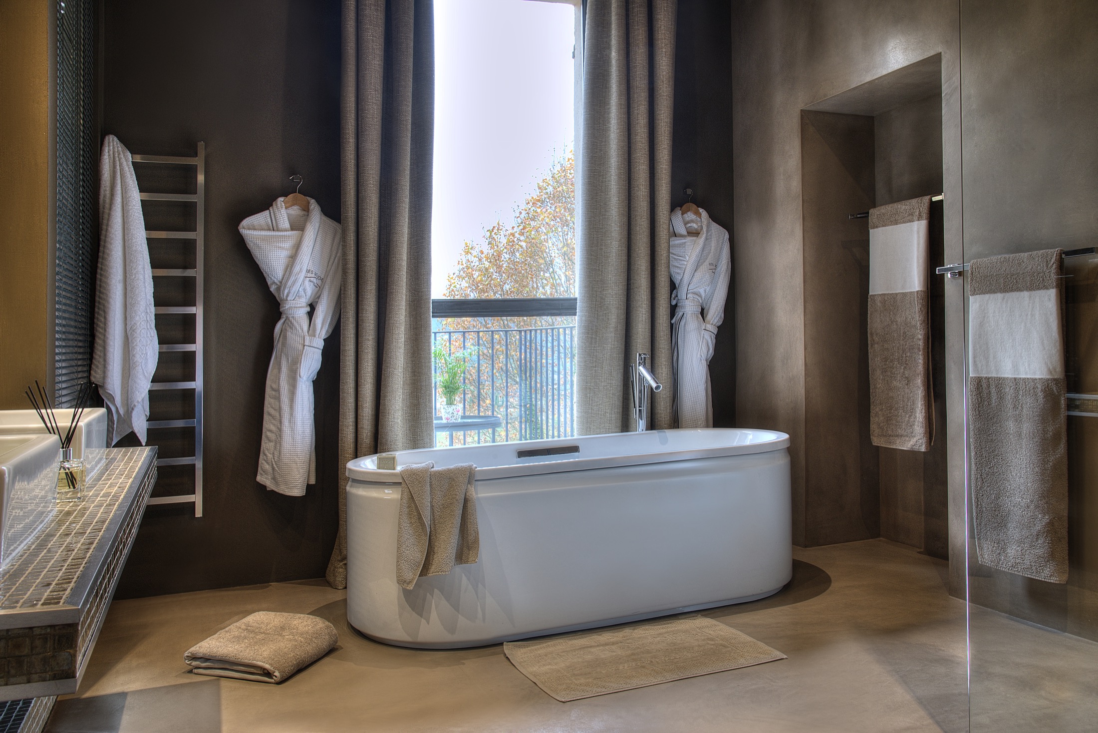 Salle de bain d’hôtel équipée de serviettes et de peignoirs