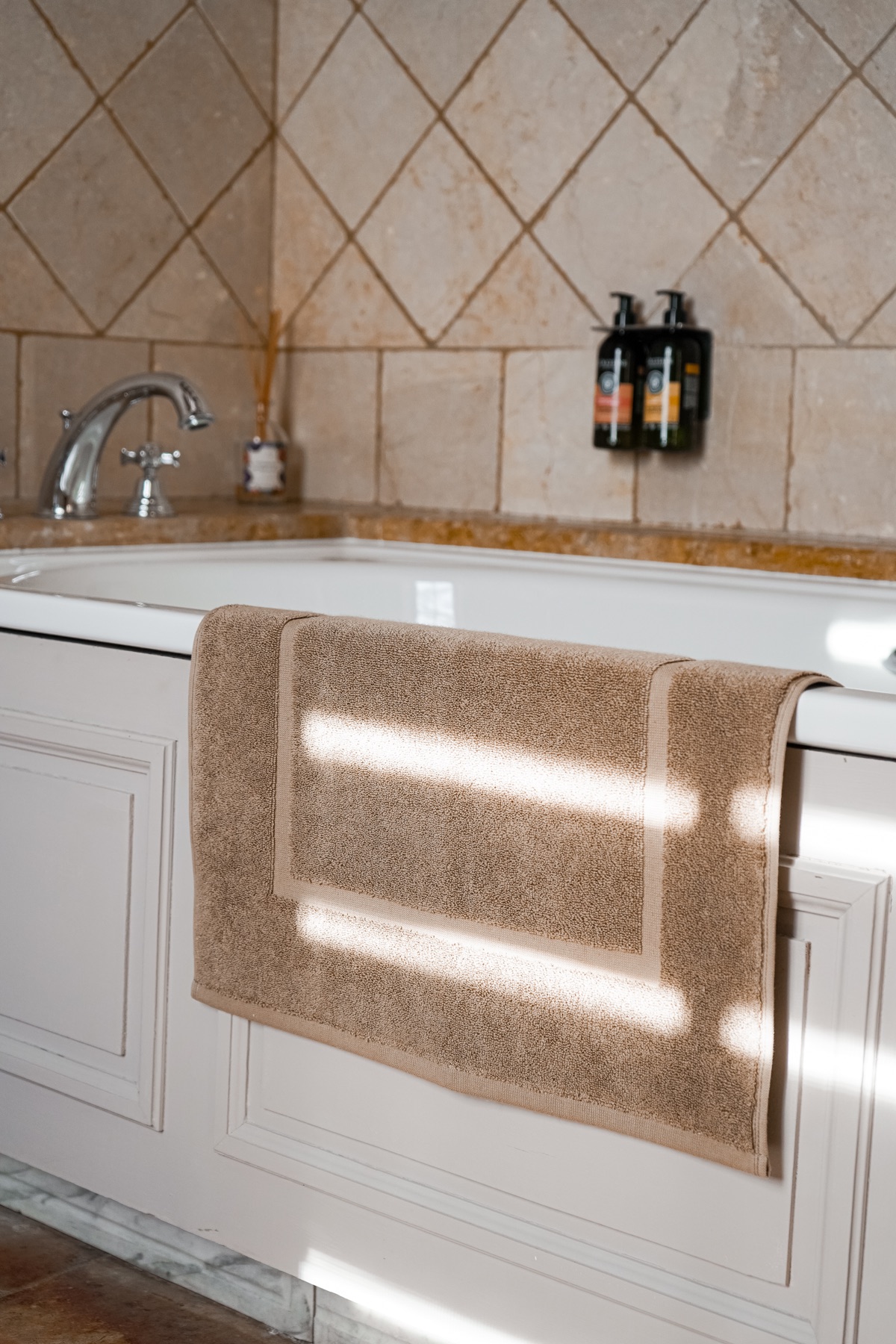Linge de bain beige disposé sur une baignoire