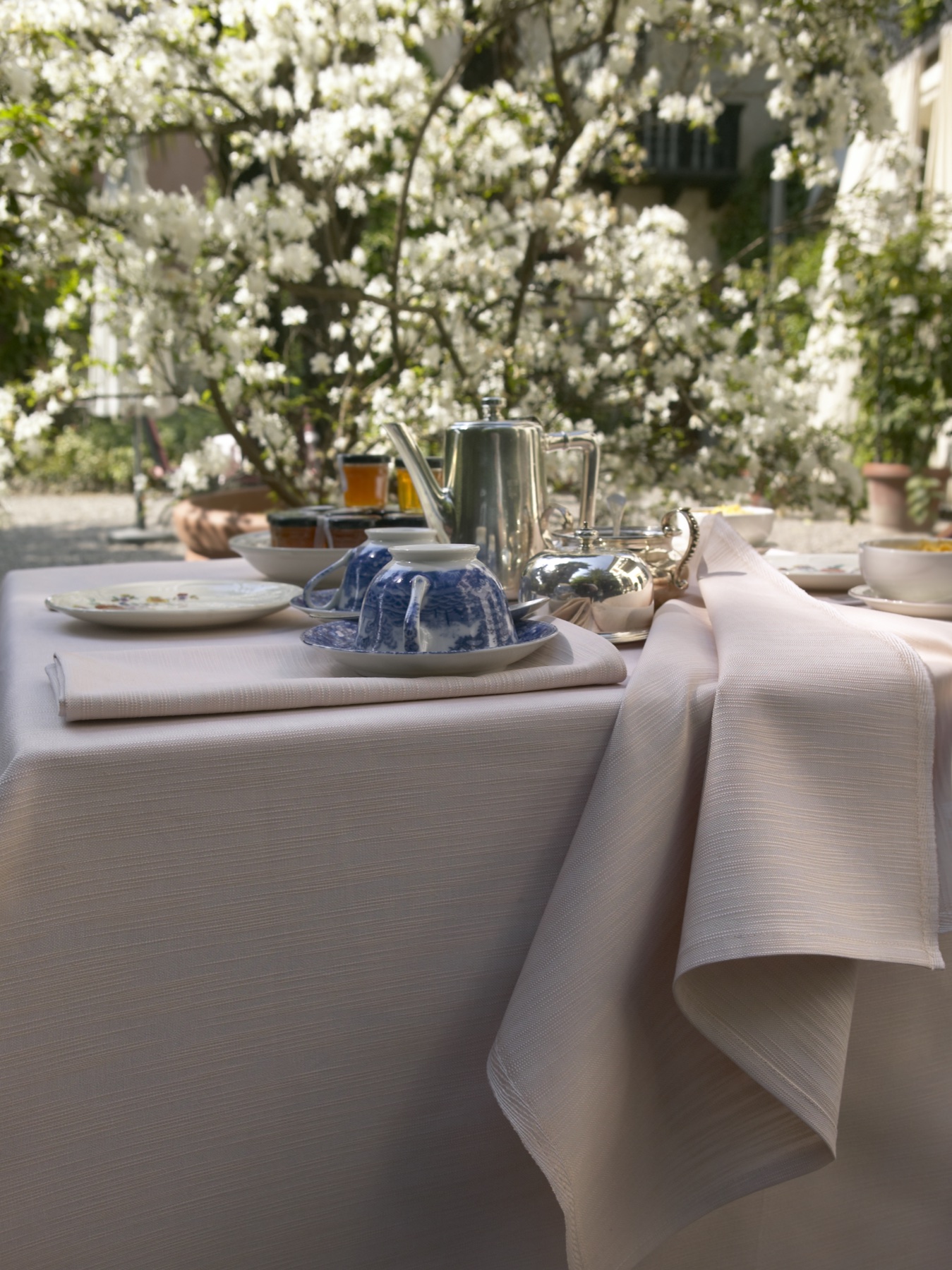 Linge de table rose poudré dressé pour un service en extérieur