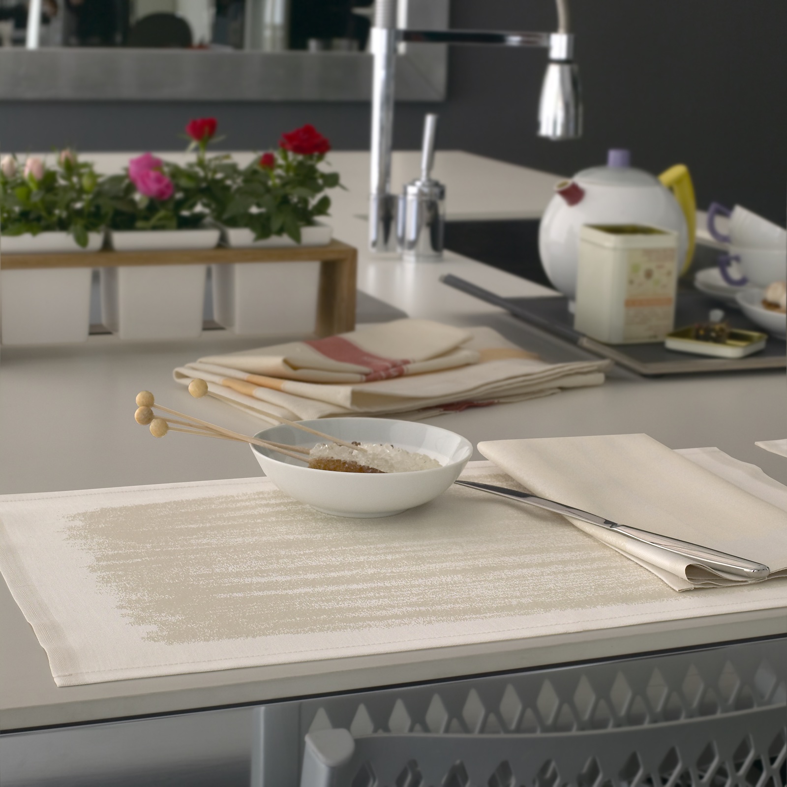 Détail d’un set et de serviettes de table aux finitions coordonnées