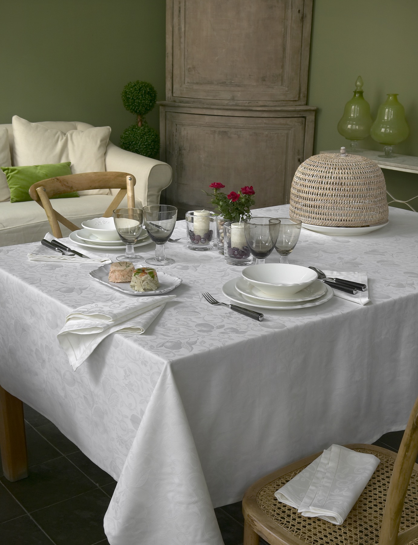 Table habillée d’une nappe blanche en jacquard et de serviettes assorties