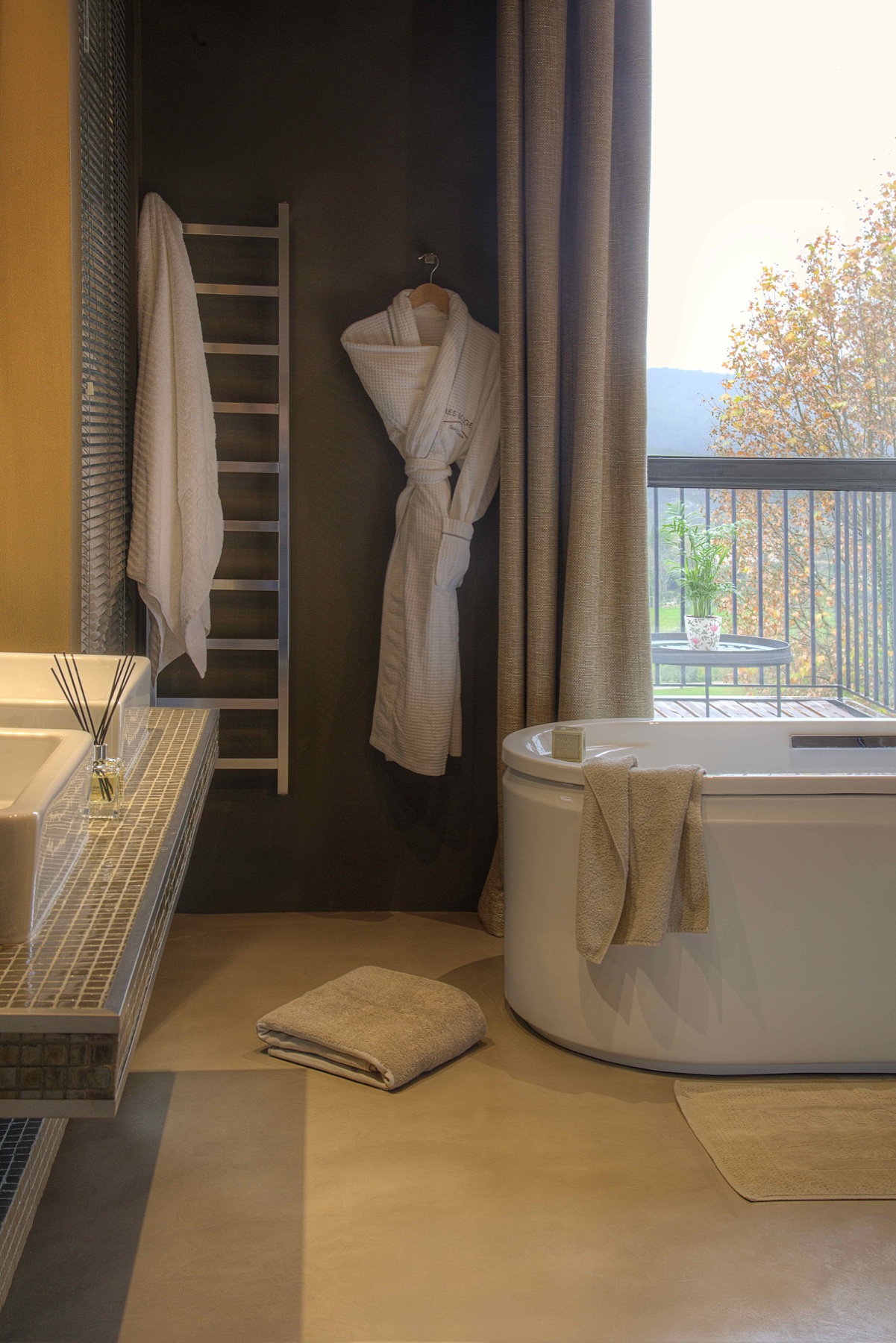 Salle de bain de spa avec peignoir, serviettes et baignoire